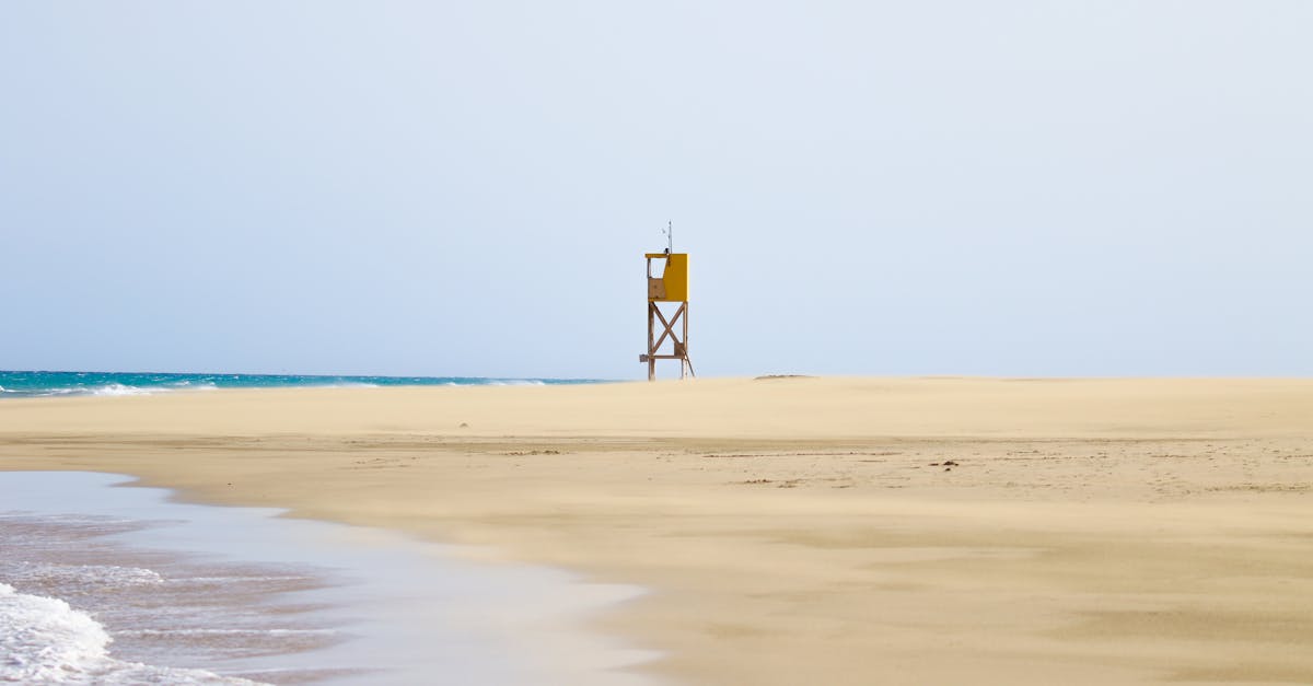 Tranquil beach scene with a solitary lifeguard tower on a sandy shore in Fuerteventura, Canary Islands.